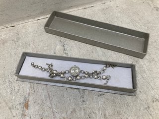 Lot 1453  
            Marchington SR13 - Parcel Delivery Only 

                
A MATCHING WATCH ND BRACELET SET, SILVER COLOURED WITH CLEAR STONES, BOXED: LOCAT...