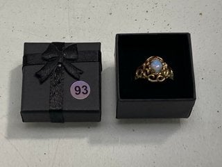 Lot 1203  
            Marchington SR13 - Parcel Delivery Only 

                
A VINTAGE GOLD COLOURED RING SET WITH A PALE BLUE OPALESCENT STONE, BOXED: LOCATI...