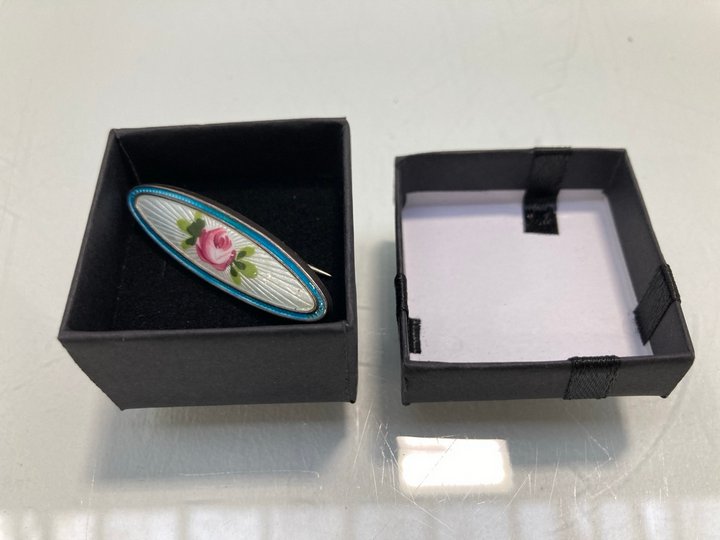 Lot 1457  
            Marchington SR13 - Parcel Delivery Only 

                
AN ANTIQUE HALLMARKED .925 SILVER AND ENAMEL BROOCH, WITH BOX: LOCATION - F10