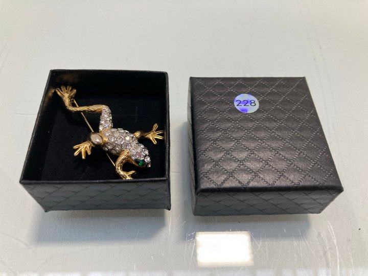 Lot 1459  
            Marchington SR13 - Parcel Delivery Only 

                
A LEAPING FROG GOLD COLOURED BROOCH SET WITH CLEAR AND GREEN STONES, WITH BOX: LO...