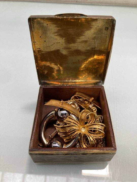Lot 1469  
            Marchington SR13 - Parcel Delivery Only 

                
AN ORIENTAL BRASS BOX WITH VINTAGE JEWELLERY CONTENTS: LOCATION - F10