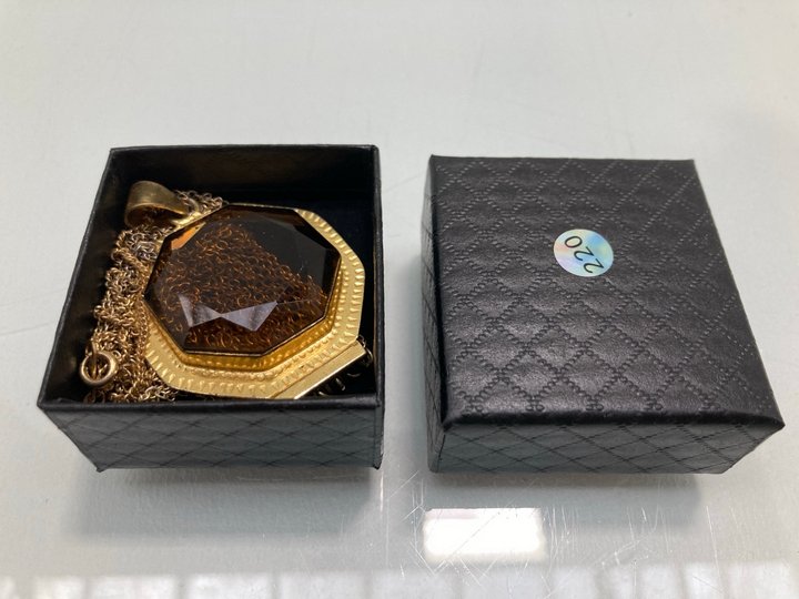 Lot 1477  
            Marchington SR13 - Parcel Delivery Only 

                
A VINTAGE AMBER COLOURED PENDANT IN A GOLD COLOURED SETTING WITH CHAIN, WITH BOX:...