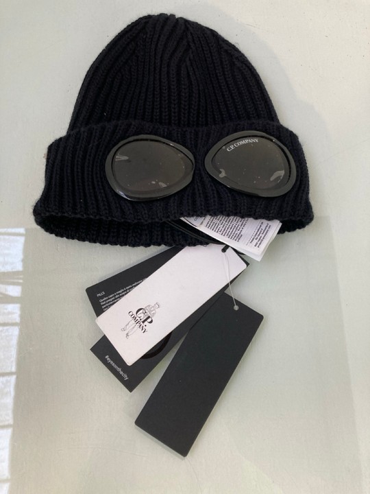 Lot 1580  
            Marchington SR15 - Parcel Delivery Only 

                
C.P COMPANY EYES ON THE CITY GOGGLE KNITTED BEANIE HAT IN BLACK - ORIGINAL RRP £1...