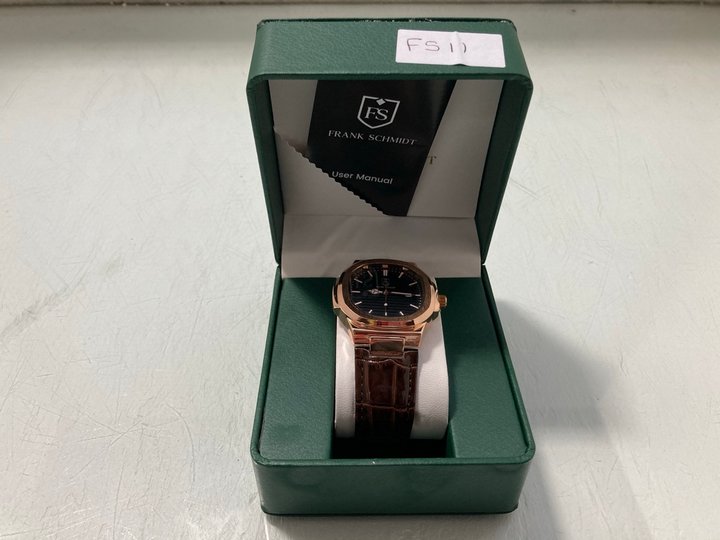 Lot 297  
            Marchington SR12 - Parcel Delivery Only 

                
FRANK SCHMIDT MEN'S AMBASSADOR WATCH. FEATURING A BLACK TEXTURED DIAL, ROSE GOLD ...