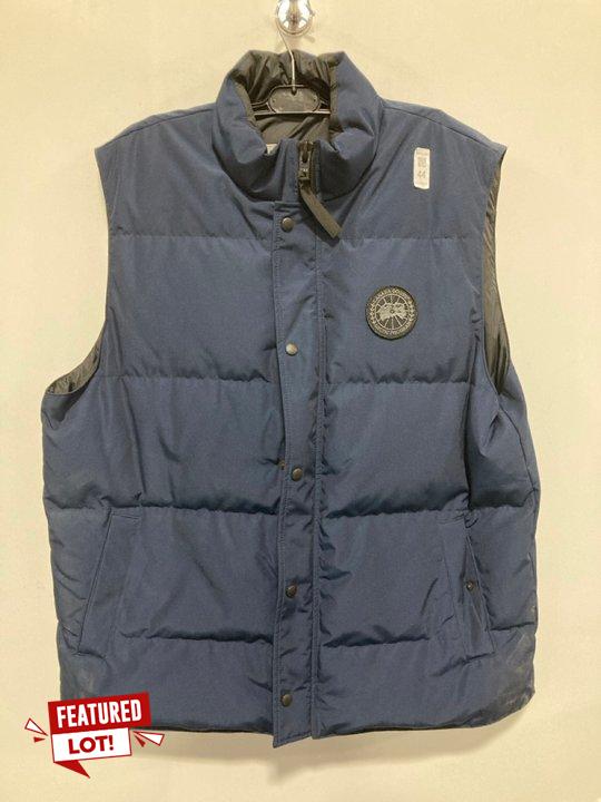 Lot 44  
            Marchington SR12 - Parcel Delivery Only 

                
CANADA GOOSE GARSON DOWN GILET IN NAVY - SIZE: 2XL - ORIGINAL RRP: £725.00: LOCAT...