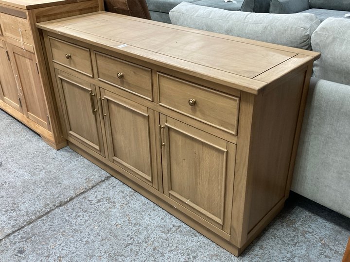 Lot 113  
            Marchington SR11 - Delivery or Collection 

                
OAK FURNITURELAND LARGE 3 DOOR 3 DRAWER SIDEBOARD IN NATURAL SOLID OAK FINISH - O...