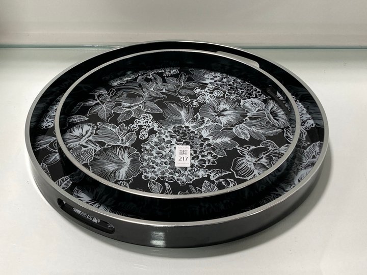 Lot 217  
            Marchington SR11 - Collection 

                
(COLLECTION ONLY) SET OF 2 FLORAL DESIGN SERVING TRAYS IN BLACK AND SILVER FINISH...