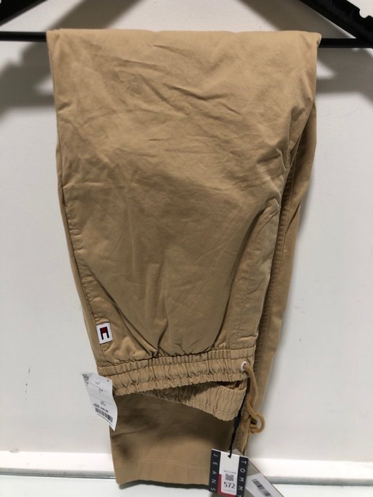 Lot 572  
            Marchington SR13 - Parcel Delivery Only 

                
TOMMY JEANS AIDEN TAPERED CASUAL PANTS IN TAWNY SAND - SIZE UK S: LOCATION - B5