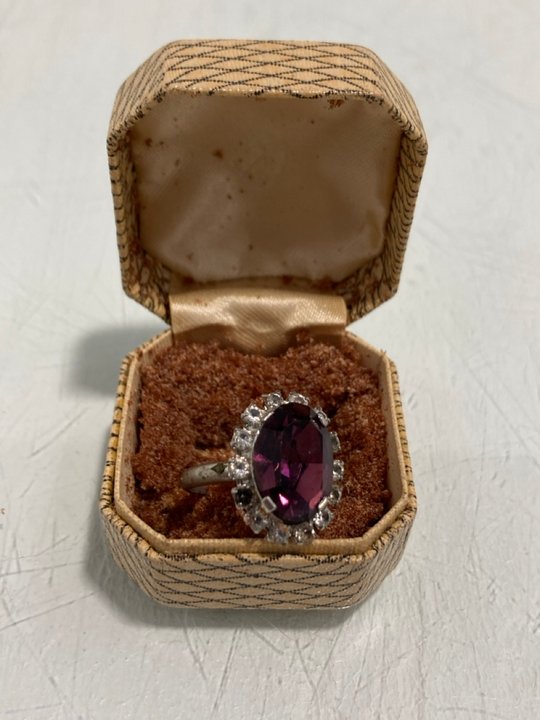 Lot 871  
            Marchington SR13 - Parcel Delivery Only 

                
A VINTAGE SILVER COLOURED RING SET WITH CLEAR STONES AND A PURPLE STONE IN A VINT...