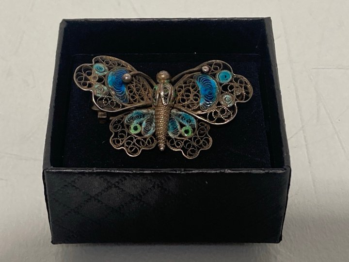 Lot 547  
            Marchington SR13 - Parcel Delivery Only 

                
AN ANTIQUE SILVER COLOURED FILIGREE BUTTERFLY BROOCH WITH BLUE ENAMEL, WITH BOX: ...