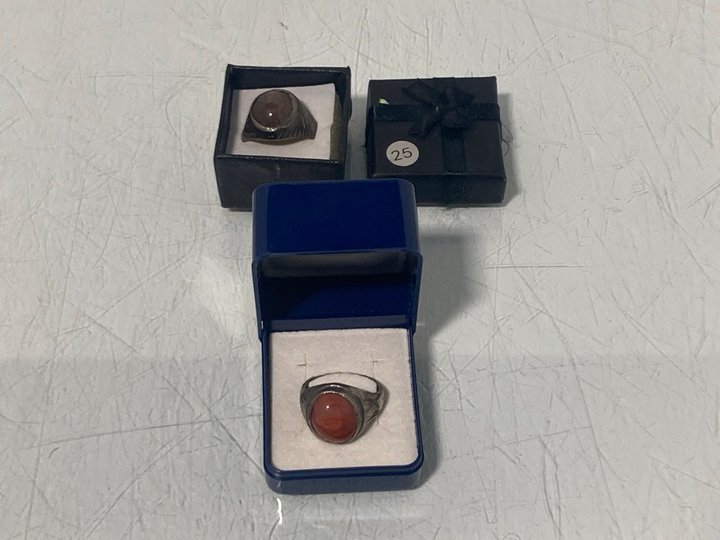 Lot 894  
            Marchington SR13 - Parcel Delivery Only 

                
2 X A SILVER COLOURED RING SET WITH A POLISHED SEMI-PRECIOUS STONE, WITH BOX: LOC...