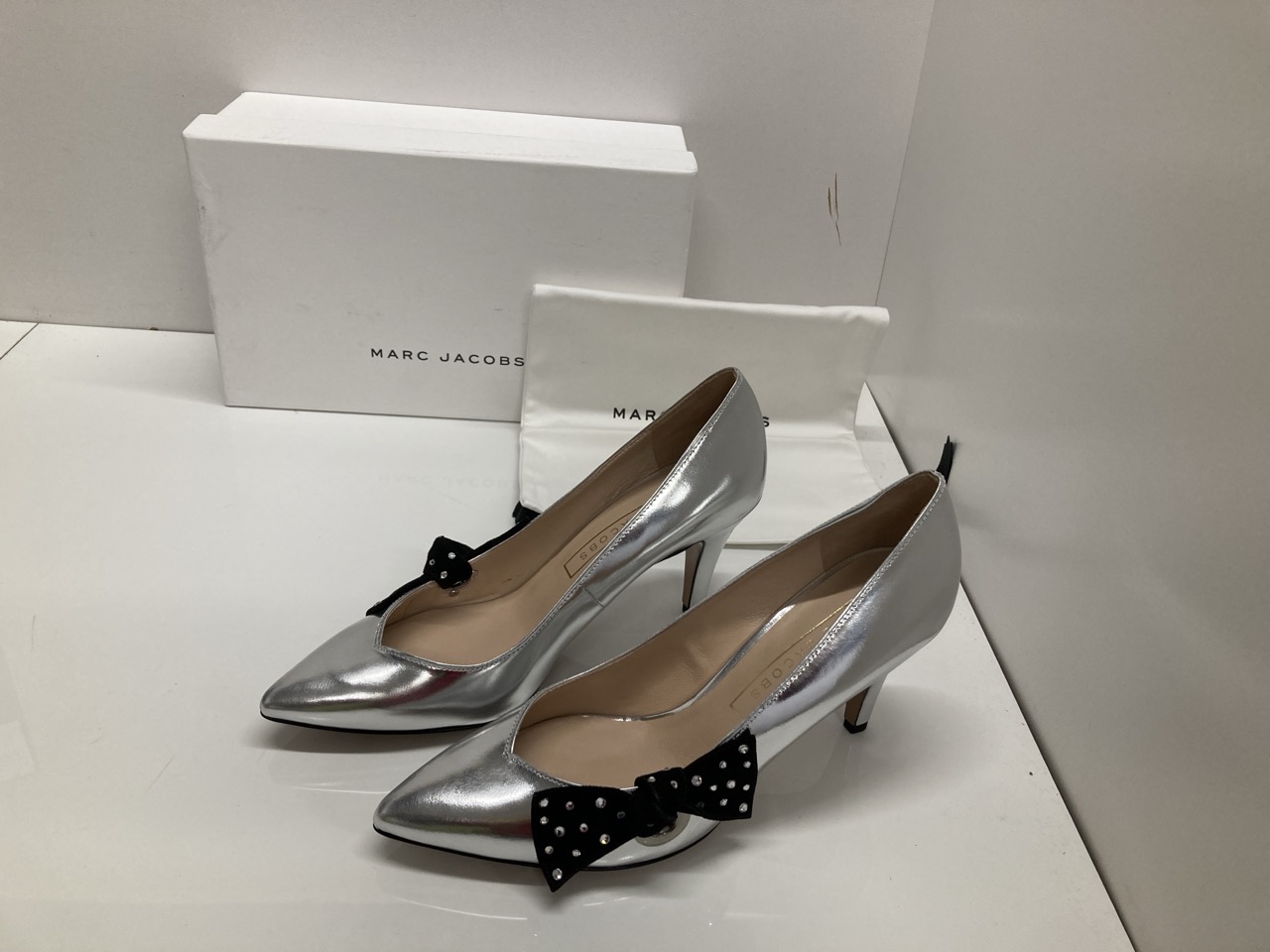 Lot 287  
            Edinburgh SR20 - Delivery Only 

                
MARC JACOBS BOW EMBELLISHED PUMPS IN METALLIC SILVER LEATHER SIZE UK 3.5: LOCATIO...