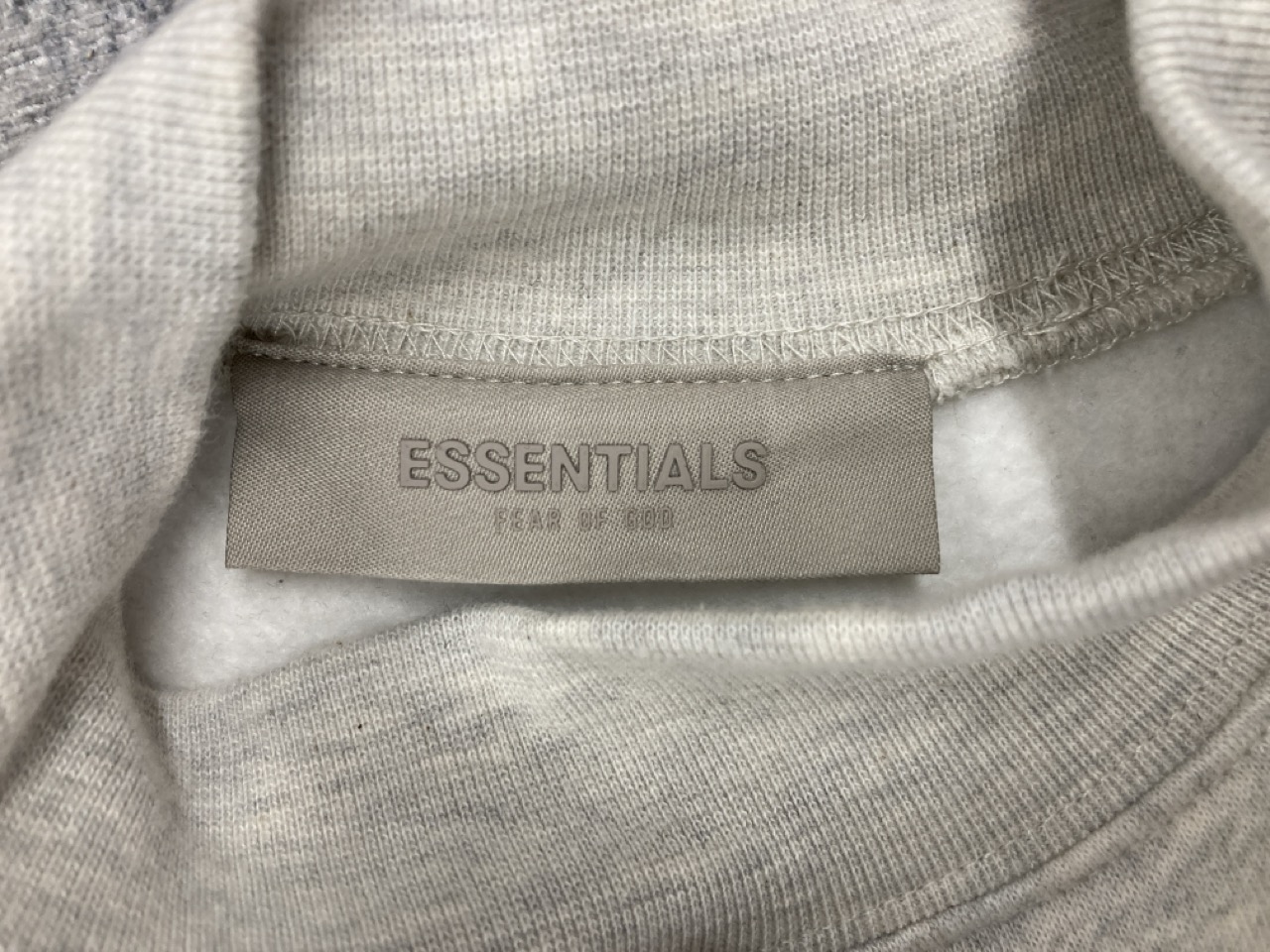 Lot 311  
            Edinburgh SR20 - Delivery Only 

                
FEAR OF GOD ESSENTIALS LOGO-FLOCKED JERSEY MOCK-NECK SWEATSHIRT IN CREAM COTTON S...